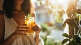 Fototapeta  - woman holding a glass of fresh orange juice, a healthy lifestyle