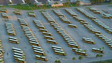 Public School Bus Parking Lot With Many Yellow Buses Parked In Rows. American Education System Transportation