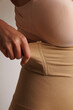 © Tatyana - Plus size pretty model in correcting figure (body) stretch beige shorts.Beautiful lady with big breasts and small waist wear underwear to correct her figure. Woman with long hair in bedroo in panties