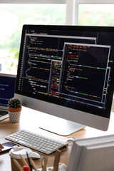 computer monitor with programming code at programmer's workplace in office