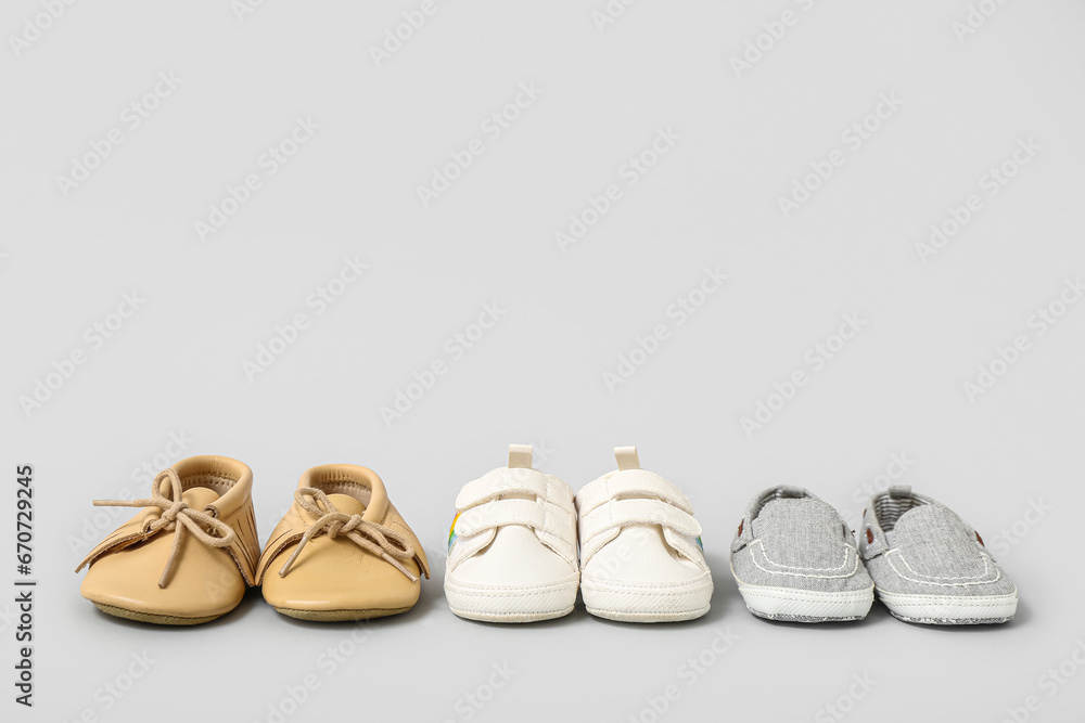 Set of baby booties on grey background