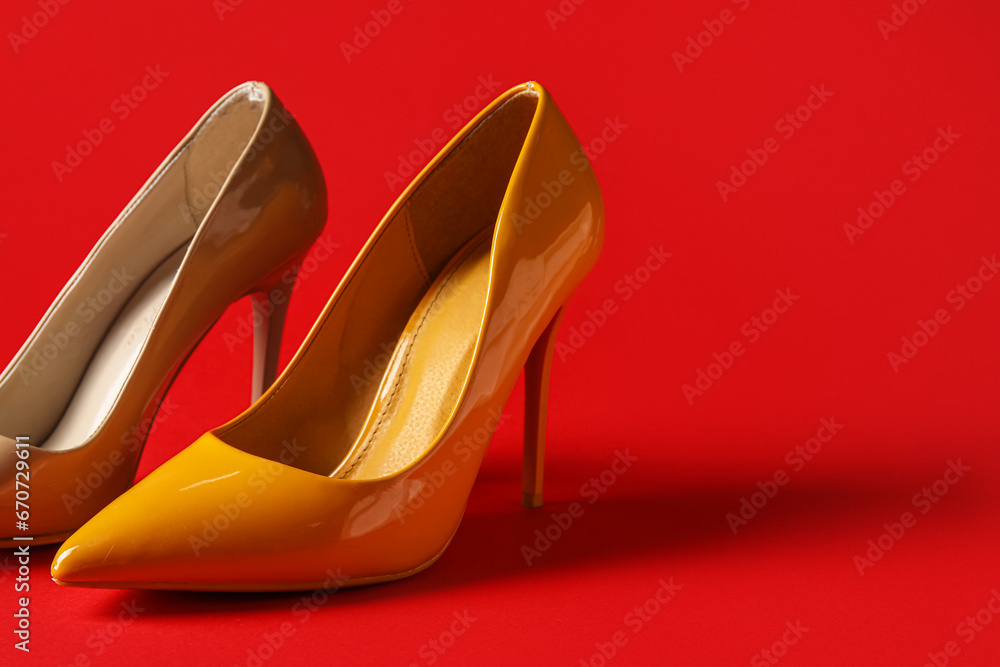 Different stylish high heels on red background