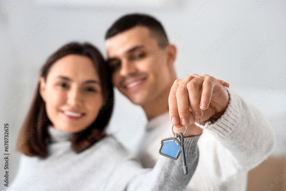 Happy young couple with key in their new flat, closeup