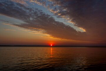 red dawn on the river, moonlit path