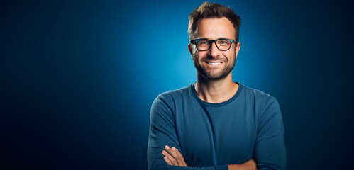 Wall Mural - man with glasses on a blue background smiling at the camera