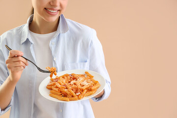 Wall Mural - Young woman with tasty pasta on beige background, closeup