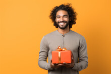 Happy Smiling Man Holding Gift Box Medium Shot Portrait Photography Of A Grinning Mature Man Holding A Gift Against A Tangerine Orange Background.