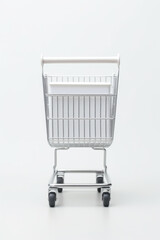 Sticker - A silver shopping cart placed on a clean white surface. Perfect for illustrating concepts related to shopping, retail, consumerism, and e-commerce