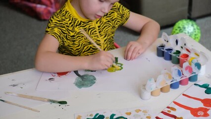 Wall Mural - Little toddler girl painting with watercolors, greeting card with flowers. Home education.  Kids art. Crafts, handmade concept. 