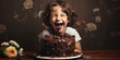 Young child laughing will eating chocolate cake