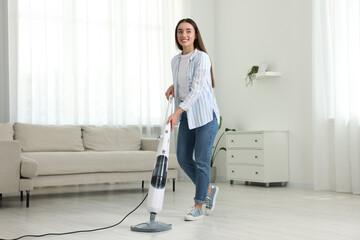 Canvas Print - Happy woman cleaning floor with steam mop at home