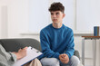 © New Africa - Psychologist working with teenage boy in office, space for text. Teenager problems