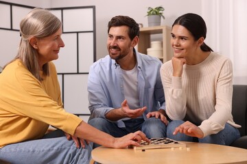 Wall Mural - Family talking while playing checkers at home