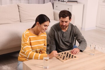 Wall Mural - Happy couple playing checkers at coffee table in room