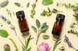 © New Africa - Bottles of essential oils and different herbs on beige background, flat lay