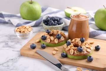 Wall Mural - Fresh green apples with peanut butter, blueberries and nuts on white marble table