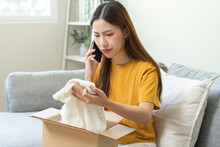 Angry Bad, Complaint Asian Young Woman Opening Carton Box, Received Online Shopping Parcel Wrong Product Order From Retail Store, Using Mobile Phone Talking With Support Shop Want To Return Package.