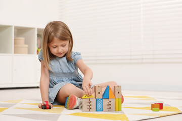 Sticker - Cute little girl playing with wooden toys indoors, space for text