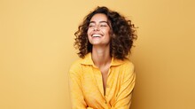Portrait Of A Cheerful Young Woman Wearing Yellow Shirt Standing Isolated Over Yellow Background, Looking At Camera, Posing