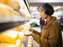 Asian-american Women Buy Cheese At The Supermarket