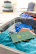 Passports and clothes in suitcase in sunny bedroom at home