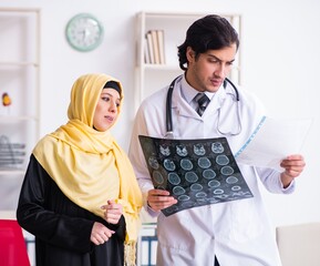 Wall Mural - Female arab patient visiting male doctor
