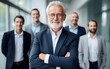 © Kowit - Portrait of successful senior businessman standing with his arms crossed businessman and businesswoman over big group of businesspe. Caucasian male entrepreneur in suit looking at camera with a smile.