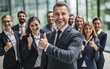 © Kowit - Businessman standing folded hand smile, businessman and businesswoman over big group of businesspeople background