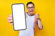 © Bangun Stock Photo - Excited young Asian man student in casual clothes backpack glasses holding mobile cell phone and saying yes, celebrating success isolated on yellow background. high school university college concept