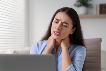 Canvas Print - Young woman suffering from neck pain in office