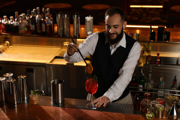 Poster - Bartender making fresh alcoholic cocktail at bar counter. Space for text