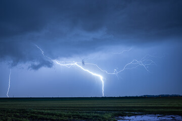 Wall Mural - exceptionally bright lightning strikes earth during a severe nighttime thunderstorm