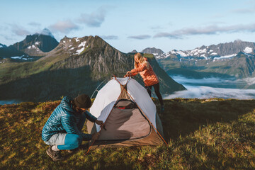 Wall Mural - Couple friends preparing their camping tent gear in Norway mountains, active vacations man and woman hiking together adventures outdoor family time healthy lifestyle