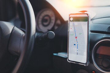 The phone's map appears on the dashboard and street in the background. White cell phone mounted in a mounting with GPS navigation and a map. duplicate the space.