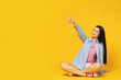 Attractive young brunette posing on a yellow background
