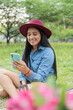 © Hector Pertuz - Latin Woman sitting by her bike checking her cell phone in the park