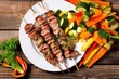 overhead view of grilled veal chops and vegetable skewers