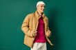 © LIGHTFIELD STUDIOS - cheerful young man in beanie hat and stylish puffer jacket on turquoise background, winter trends