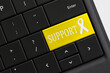 Online help Support Concept - keyboard with YELLOW support awareness ribbon key button.