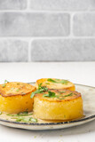 Fototapeta Tulipany - Potato fondant, tender potatoes in pucks, close-up, Vertical photo.