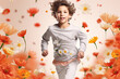 Cute child in gray sportswear runs against falling flowers background.