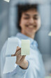 © Katsiaryna - a girl in a modern office behind glass uses sticky notes and makes notes