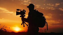 Video Stabilizer Operator. Taking Video Shoots Using DSLR Gimbal Equipment. Sunset Silhouette Concept. 