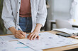© DragonImages - Businesswoman taking notes on stickers when working with reports and diagrams