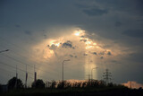 Fototapeta Na ścianę - Promienie słoneczne przebijają, prześwietlają przez chmury.