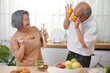 senior couple having fun and enjoy cooking salad in the kitchen