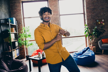 Poster - Photo portrait of attractive young man wear yellow shirt excited dancing have fun modern workplace room home design