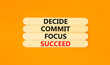 Decide commit focus succeed symbol. Concept word Decide Commit Focus Succeed on beautiful wooden stick. Beautiful orange background. Business decide commit focus succeed concept. Copy space.