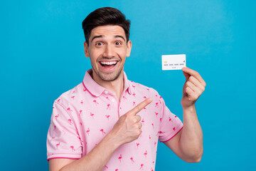 Sticker - Photo of impressed handsome guy indicate finger hand hold plastic debit card isolated on blue color background