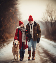 Loving Family Walking With Their Golden Retriever Dog On A Snowy Country Road. Smiling Woman And Older Man Wearing Red Christmas Hats, Taking A Walk On A Calm Winter Day.